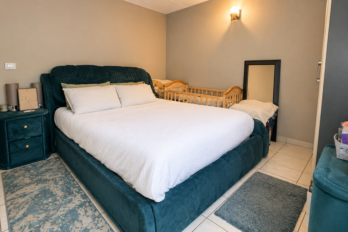 A well-maintained bedroom featuring tiled flooring, neutral wall tones, and a built-in wardrobe, providing a functional and comfortable living space.
