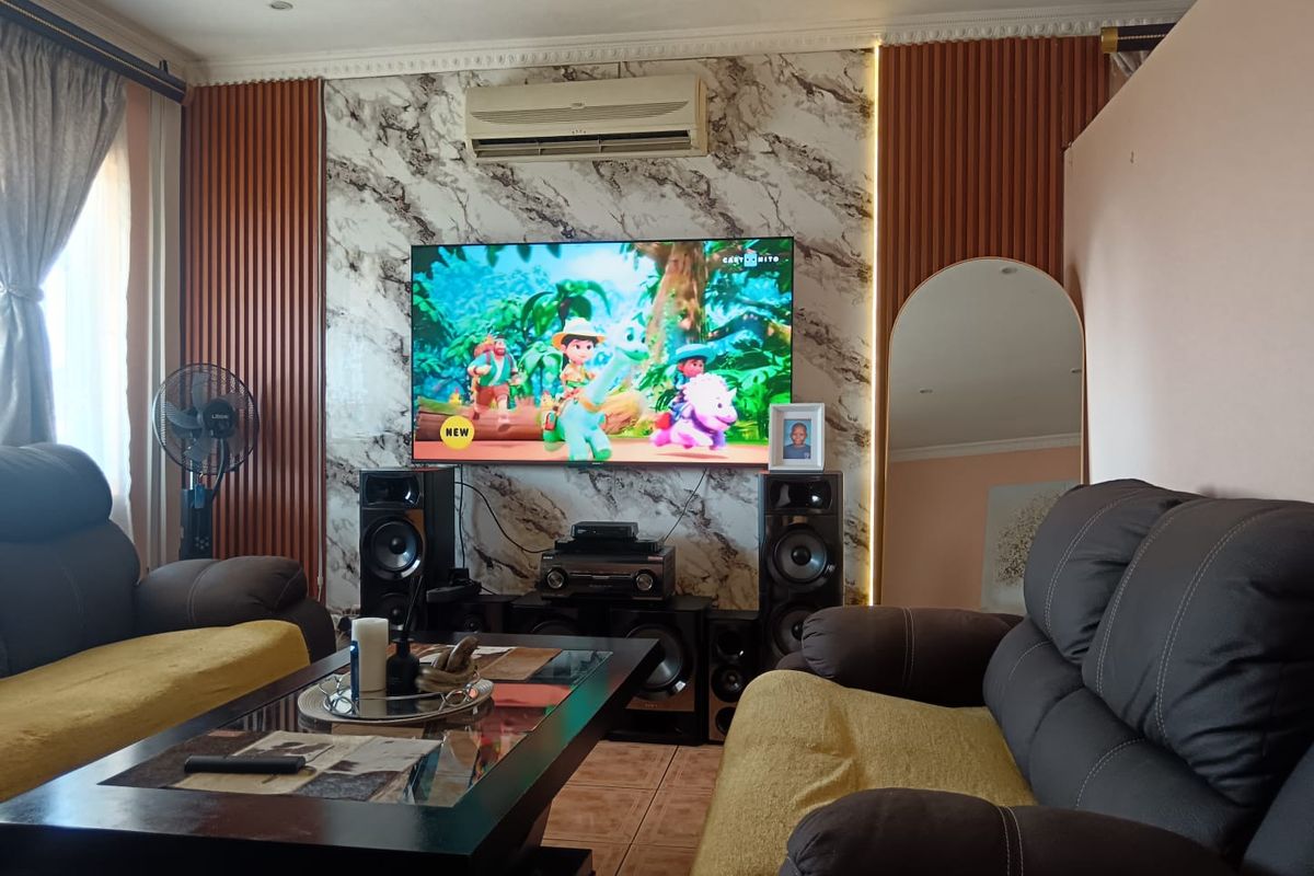 A comfortable living room featuring a marble-effect feature wall with decorative wood paneling, recessed lighting, and a wall-mounted air conditioning unit.