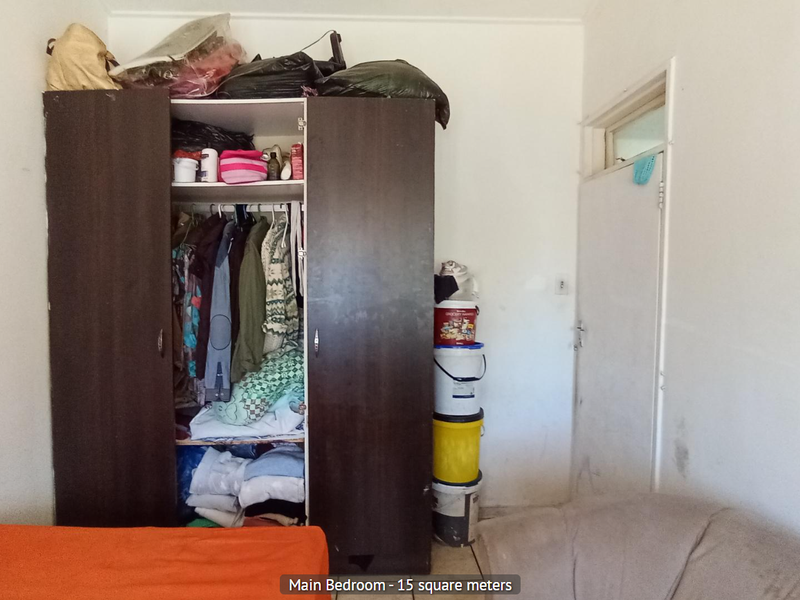 A bedroom featuring a built-in wardrobe and an internal door, requiring cosmetic updates to the wall finishes.