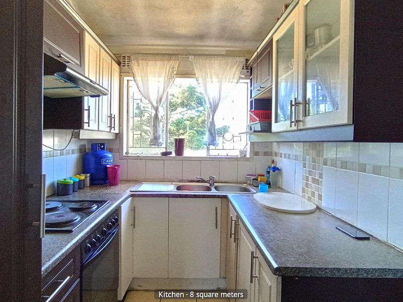 Compact kitchen featuring built-in cabinetry, laminate countertops, a stainless steel sink, and an integrated electric stove with an extractor fan.
