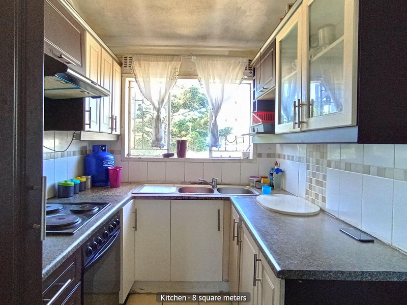 Compact kitchen featuring built-in cabinetry, laminate countertops, a stainless steel double sink, and an integrated electric hob and oven.