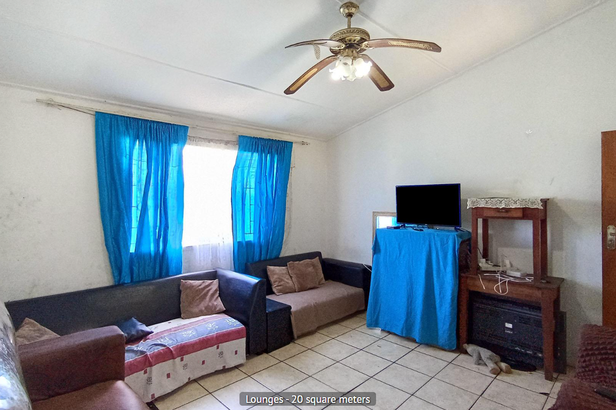A living room featuring ceramic floor tiles, a ceiling fan, and a timber door, requiring cosmetic updates to improve its overall condition.