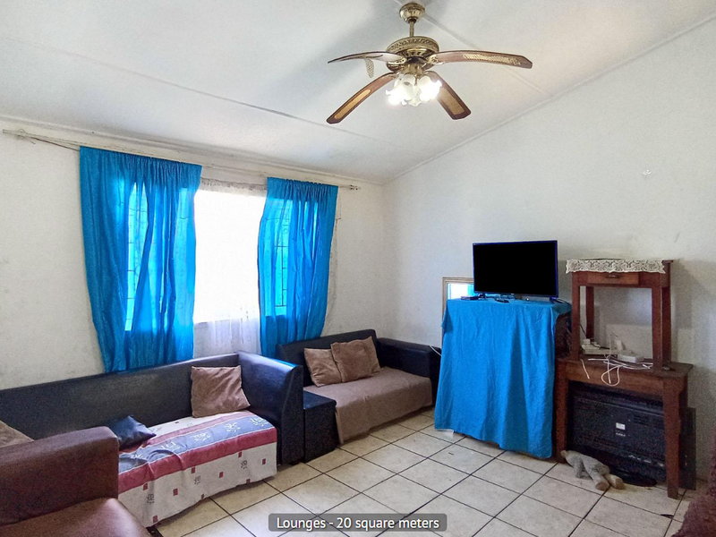 A living room featuring ceramic floor tiles, a ceiling fan, and a timber door, requiring cosmetic updates to improve its overall condition.
