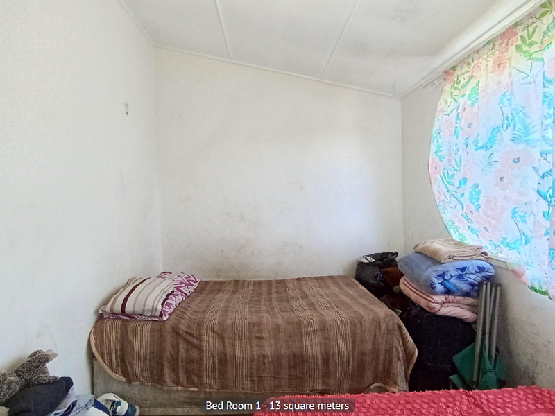 A bedroom space measuring 13 square meters, featuring plain walls and a window with curtains.