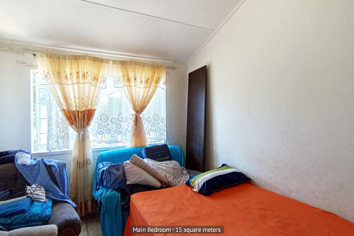 A bedroom featuring a window with a curtain rod, offering a functional space that would benefit from cosmetic updates and fresh paint.