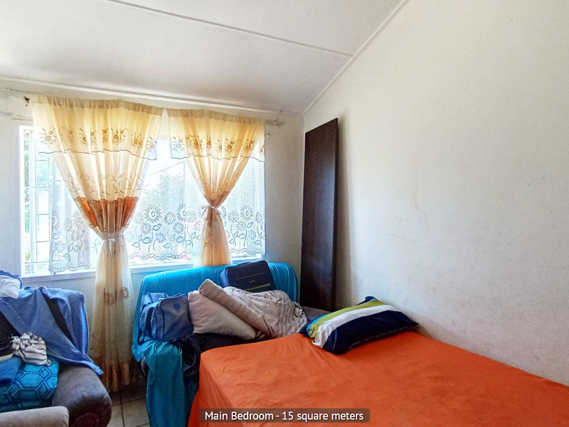 A bedroom featuring a window with a curtain rod, offering a functional space that would benefit from cosmetic updates and fresh paint.