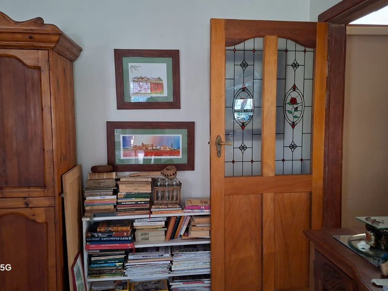 A view of an interior hallway featuring a classic timber door with decorative stained glass panels.