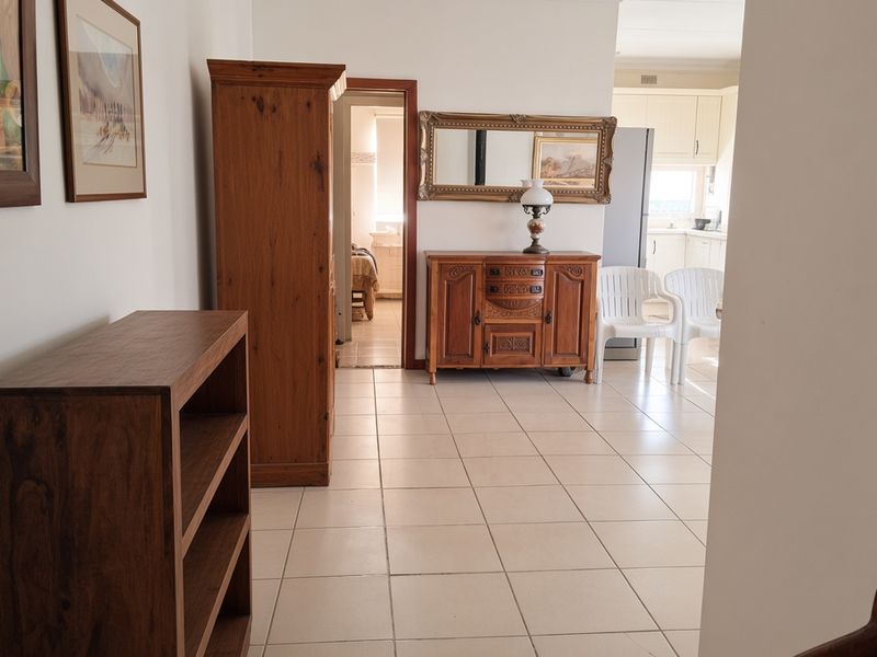 A tiled hallway area providing access to adjacent rooms, including a view into the kitchen and a bedroom.
