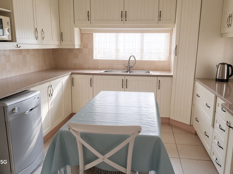 A functional kitchen featuring cream-colored cabinetry, tiled backsplash, laminate countertops, and a stainless steel sink with natural light from the window.