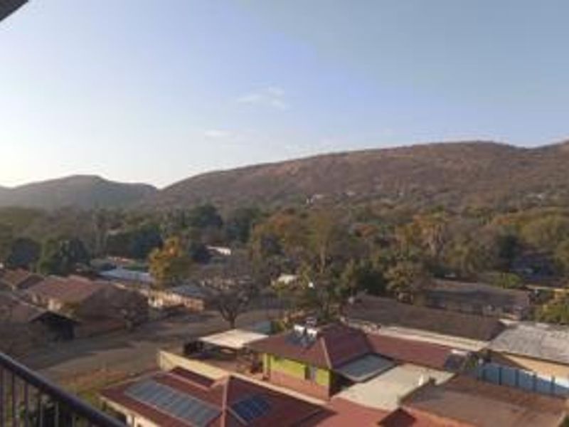 Elevated scenic view overlooking the surrounding neighbourhood and distant hills, captured from a balcony.