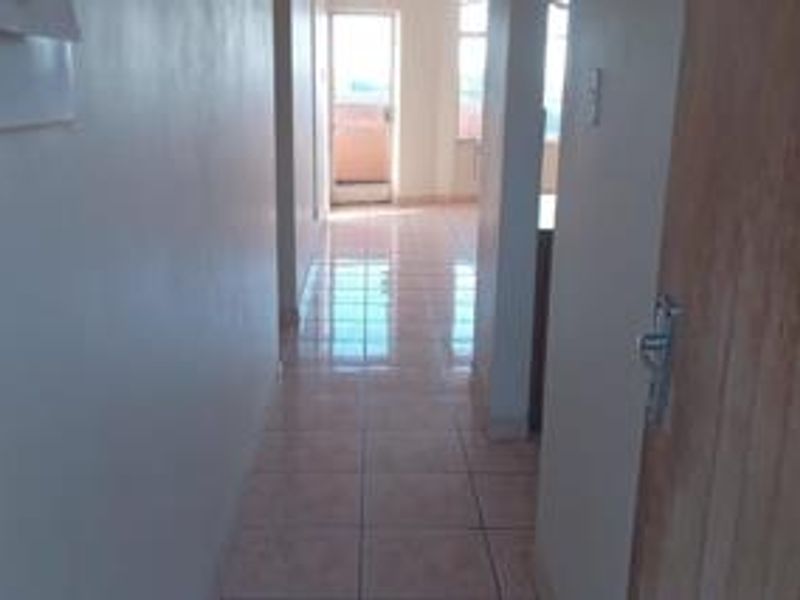 A simple, tiled hallway providing access to other areas of the apartment, featuring neutral walls and standard internal doors.
