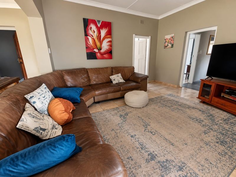 Spacious living room featuring neutral wall tones, tiled flooring, and an open archway leading to adjacent areas of the home.