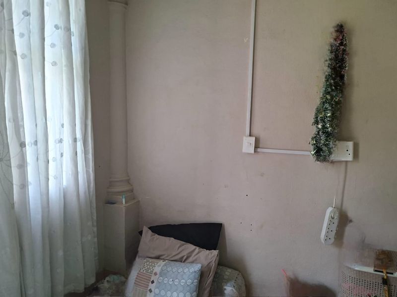 A bedroom interior featuring a decorative column and surface-mounted electrical conduit, requiring cosmetic updates to the wall finishes.