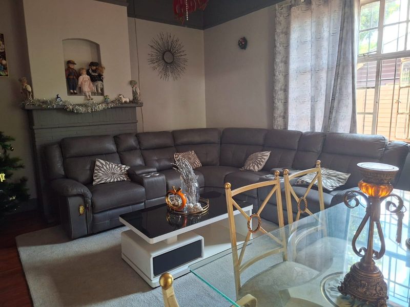 A living room featuring a fireplace with a built-in display niche and timber flooring, offering a comfortable and traditional living space.