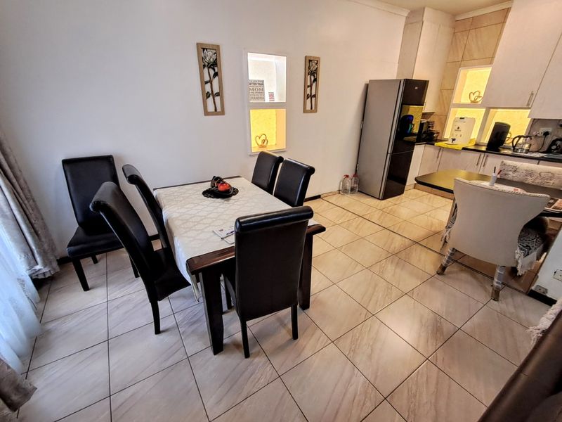 Open plan dining and kitchen area featuring tiled flooring, built-in cabinetry, and decorative recessed wall niches.