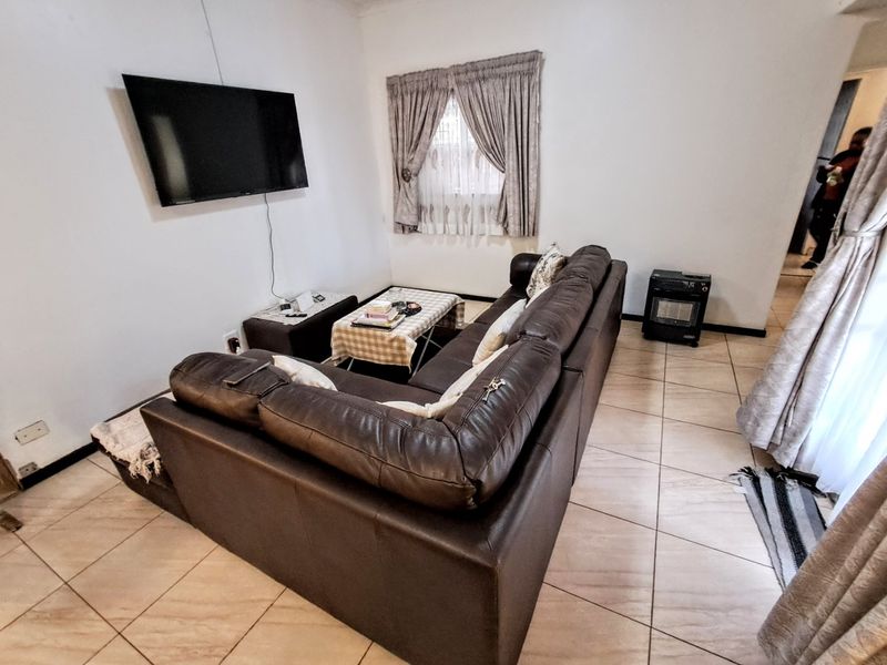 A functional living room featuring tiled flooring and neutral wall finishes, providing a comfortable space for relaxation.