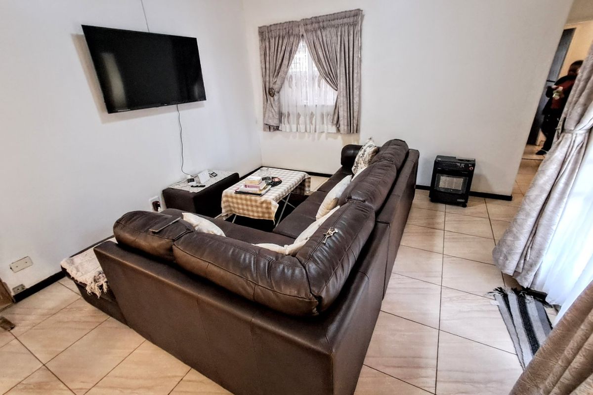 A functional living room featuring tiled flooring and neutral wall finishes, providing a comfortable space for relaxation.