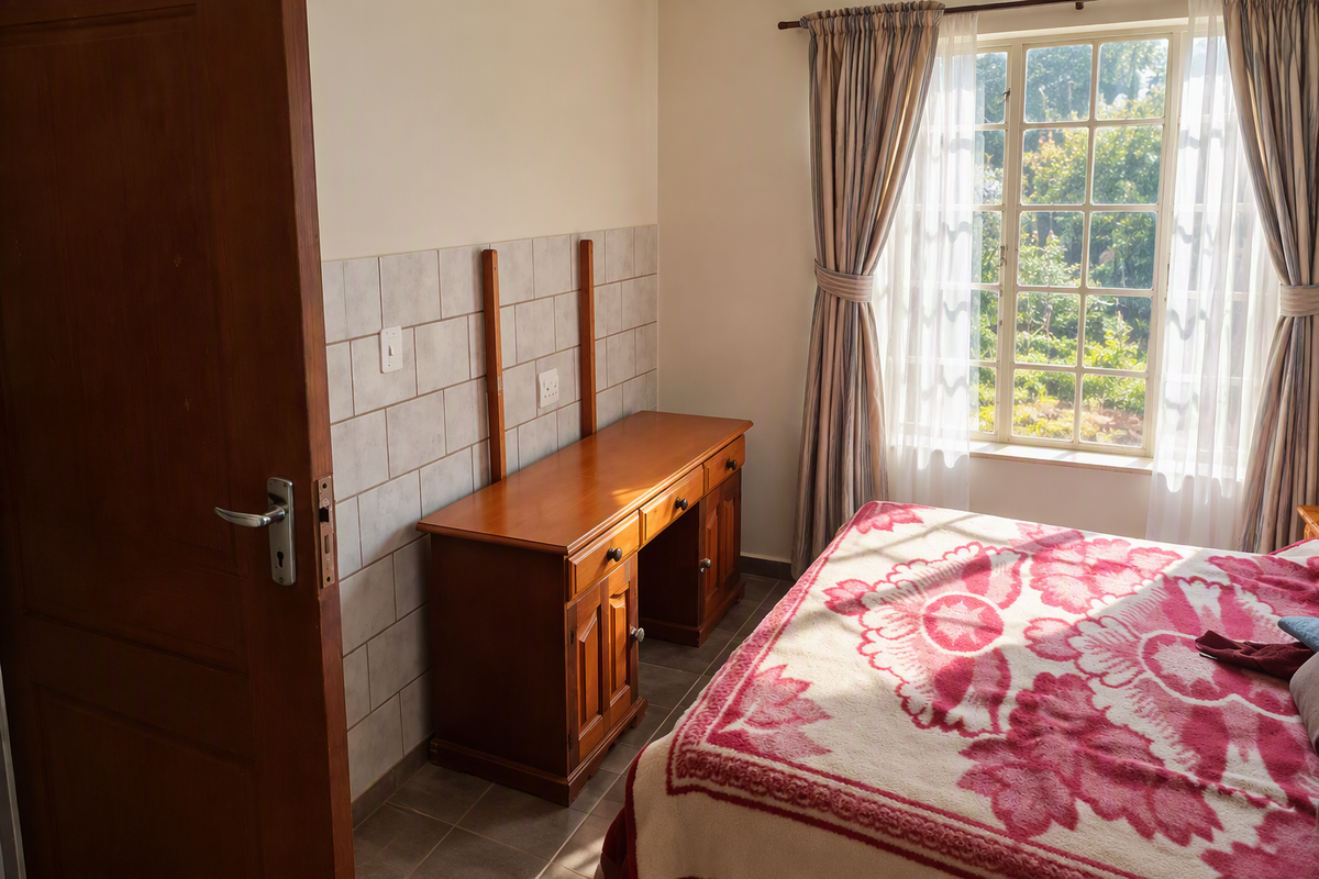 A bedroom featuring tiled wall accents, a wooden door, and a grid-pattern window allowing natural light into the space.