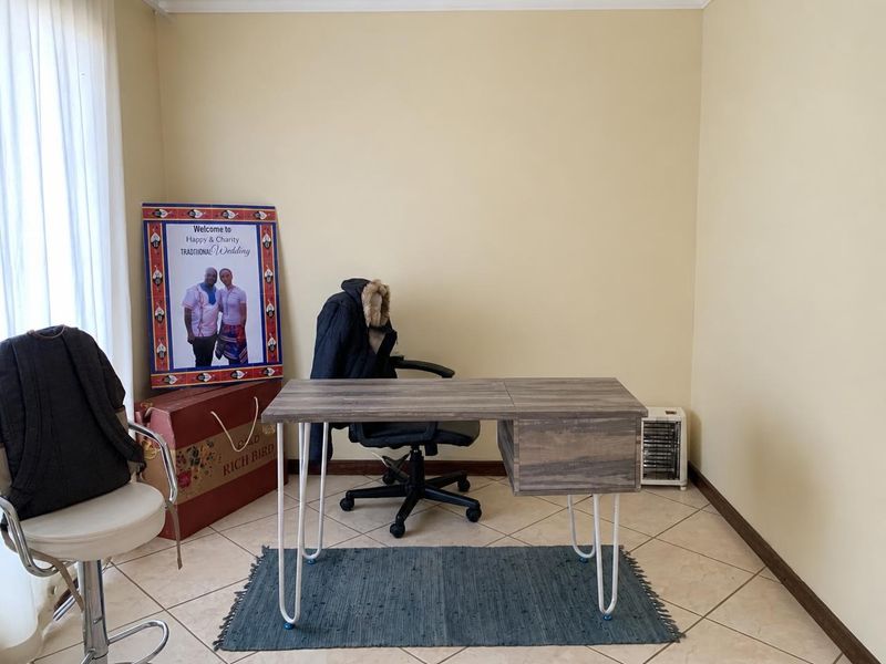 A functional home office space featuring neutral wall tones and tiled flooring, suitable for a dedicated workspace or study area.