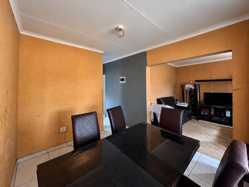 Open plan living and dining area featuring tiled flooring and neutral wall finishes, offering a versatile space for family living and entertaining.