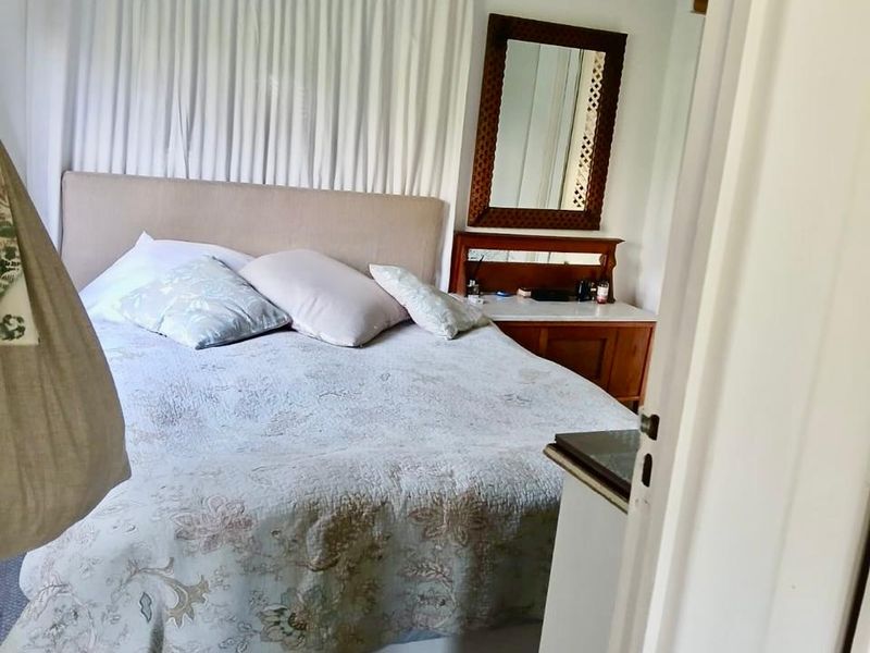 A cozy bedroom featuring a ceiling fan and original timber flooring, offering a comfortable and inviting space.