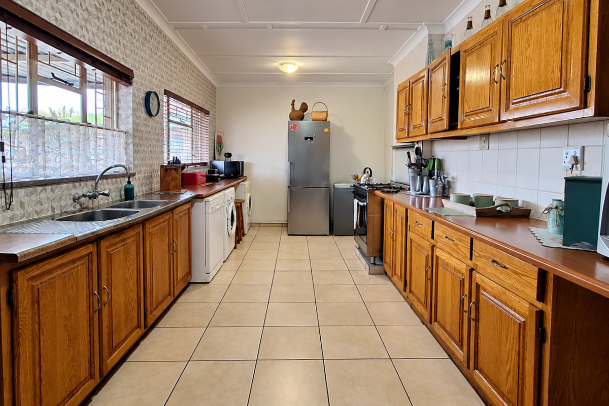 A functional galley-style kitchen featuring wooden cabinetry, laminate countertops, tiled flooring, and a tiled backsplash with integrated appliance spaces.