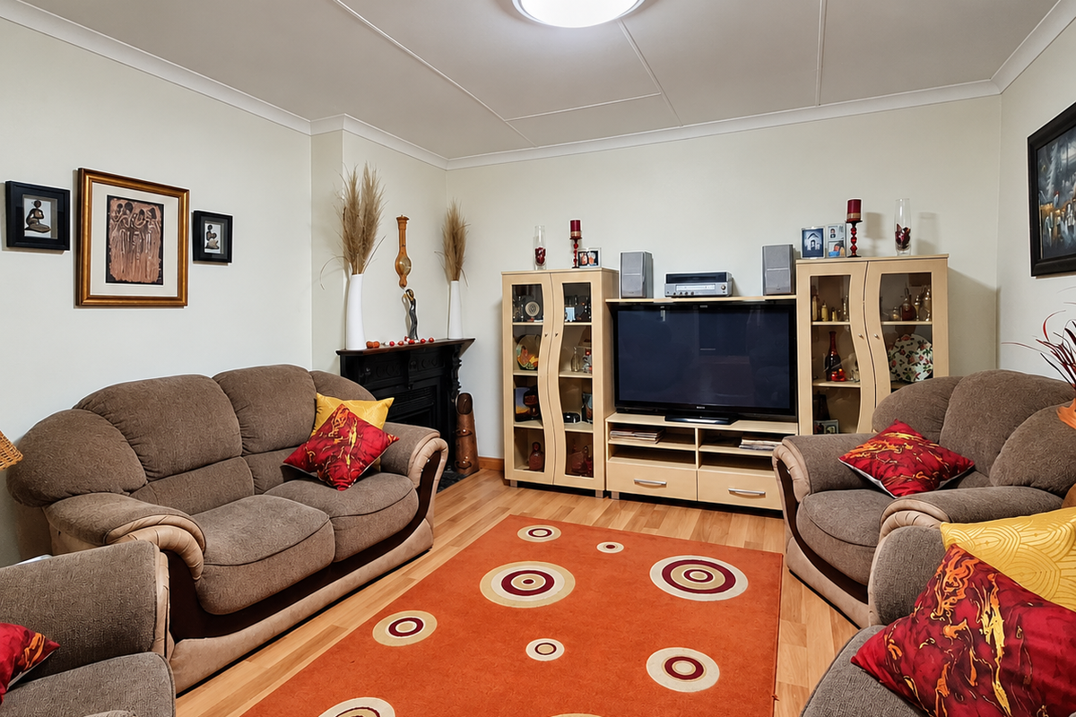 A comfortable living room featuring laminate flooring, a fireplace, and a central ceiling light fixture, providing a functional and inviting space.