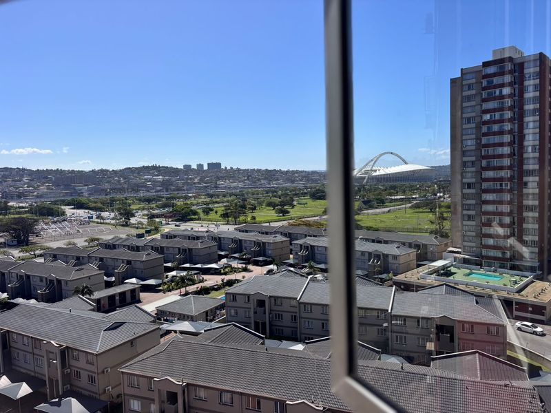 Elevated urban view overlooking surrounding residential apartment complexes and a distant stadium.