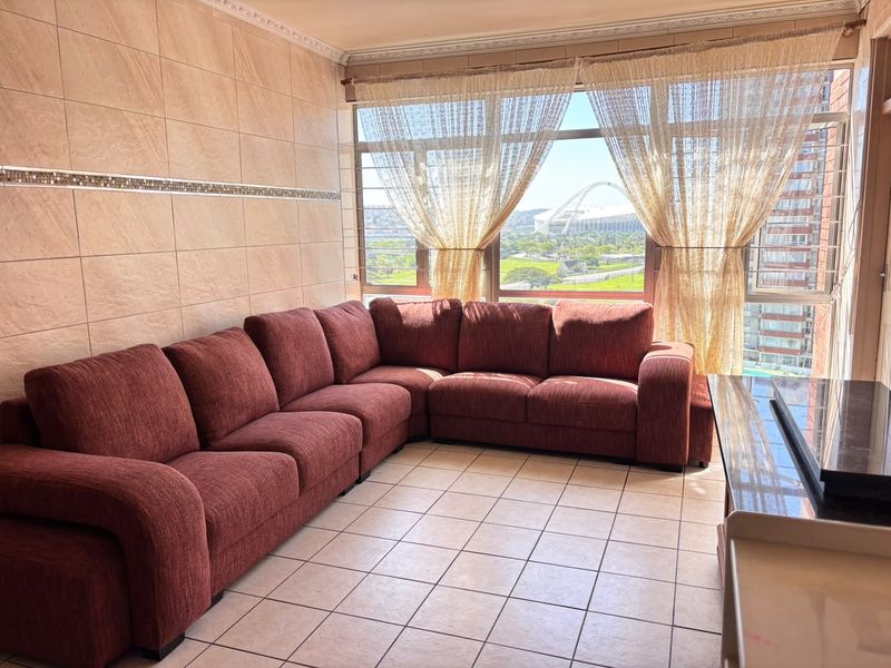 A living room featuring ceramic floor tiles, wall tiling, and large windows with security bars, offering a view of the stadium.