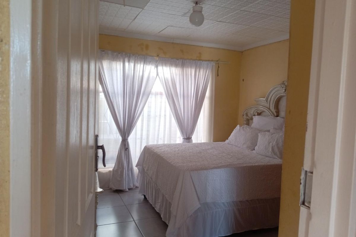 A bedroom featuring tiled flooring and ceiling tiles, requiring cosmetic updates to the wall paint and ceiling finish.