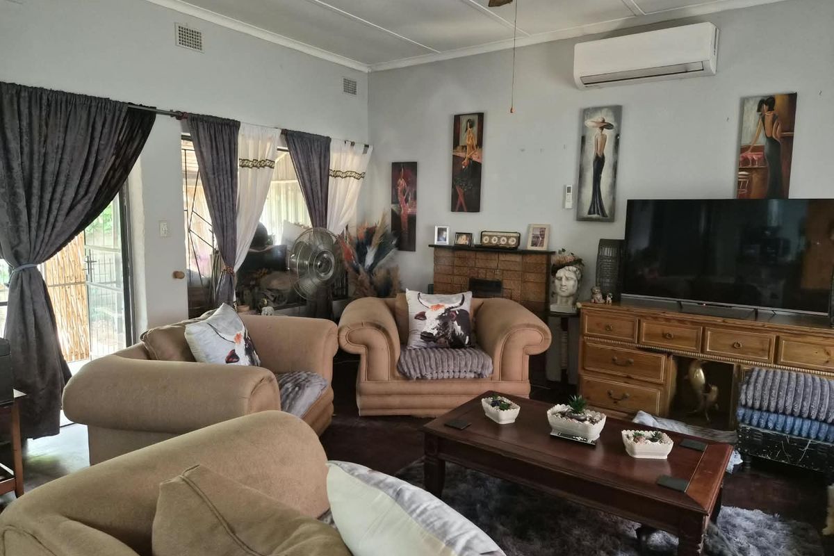 A comfortable living room featuring a split-system air conditioner, ceiling fan, and sliding glass door access to the exterior.