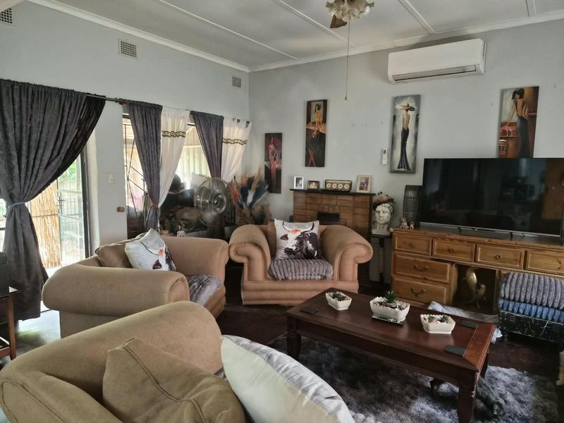 A comfortable living room featuring a split-system air conditioner, ceiling fan, and sliding glass door access to the exterior.