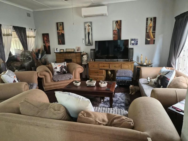 A comfortable living room featuring a brick fireplace and a wall-mounted split-system air conditioner, providing a functional and cozy space.