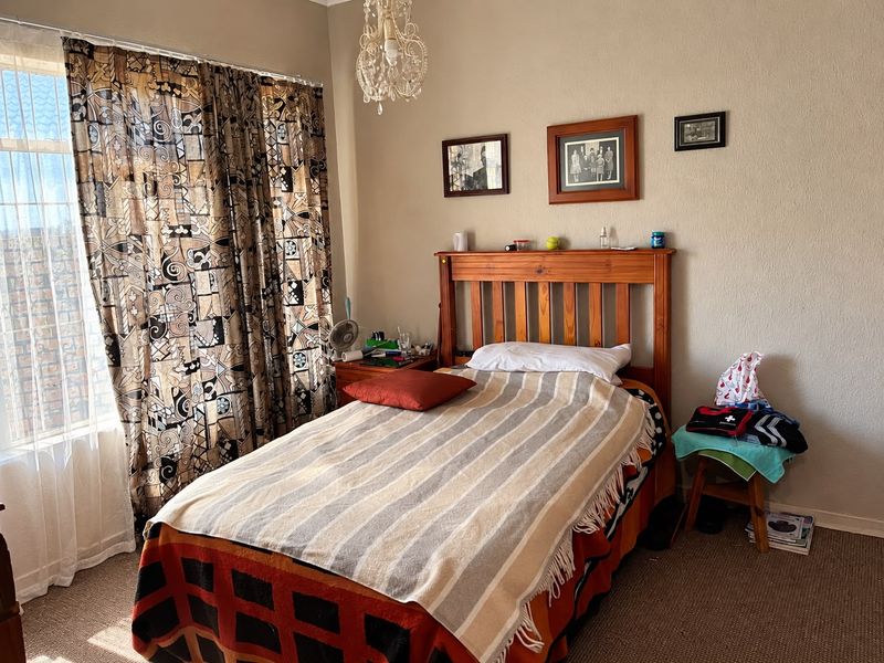 A standard bedroom featuring carpeted flooring and a central ceiling light fixture, providing a functional living space.