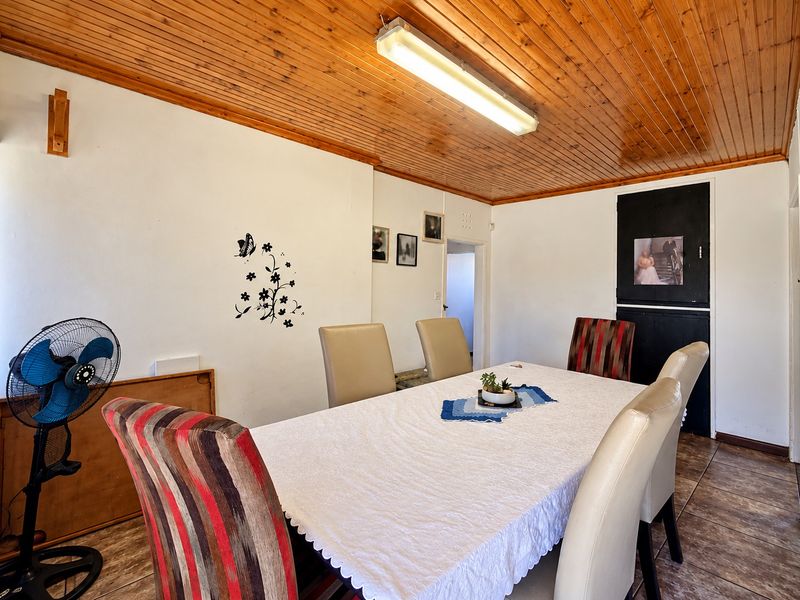 Dining room featuring a timber tongue and groove ceiling, tiled flooring, and a central fluorescent light fixture.