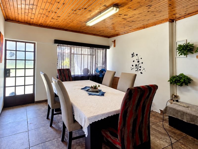 Dining room featuring tiled flooring, a timber tongue and groove ceiling, and direct access to the exterior through a glazed timber door.
