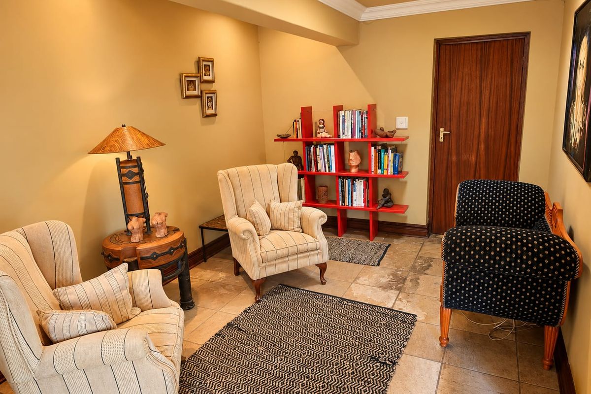 A cozy living area featuring stone tile flooring, crown molding, and a solid wooden door, offering a comfortable space for relaxation.