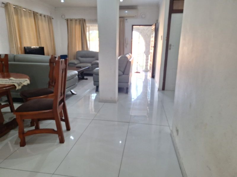 Open plan living area featuring polished tiled flooring, a central structural column, and an integrated air conditioning unit.