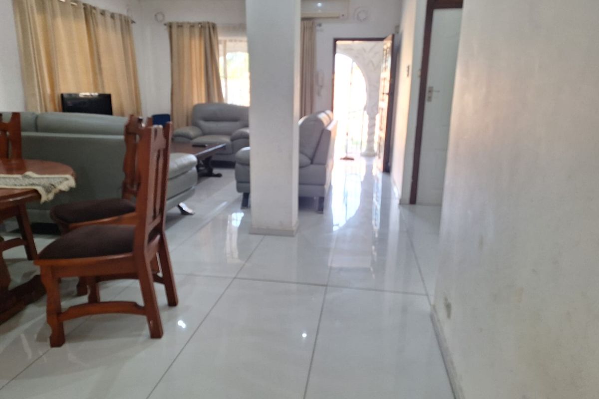 Open plan living area featuring polished tiled flooring, a central structural column, and an integrated air conditioning unit.