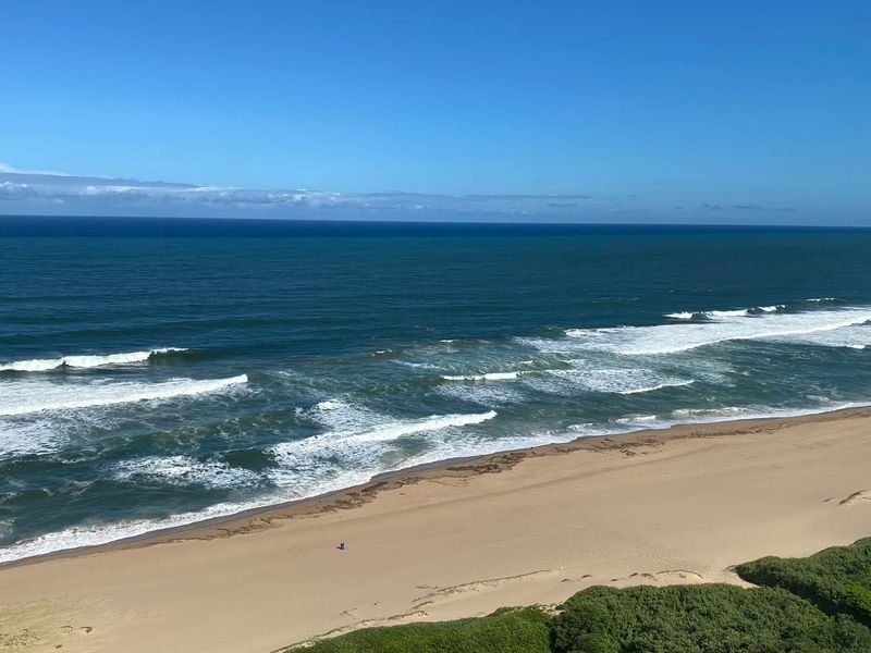 A scenic elevated view of the ocean coastline and sandy beach.