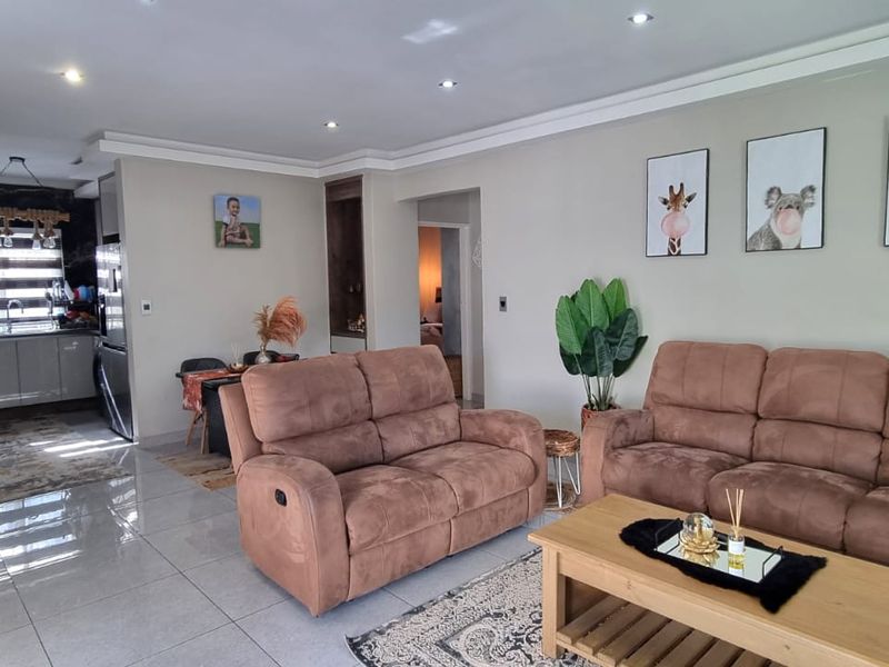 Spacious open-plan living area featuring modern tiled flooring, recessed lighting, and a functional kitchen with contemporary cabinetry and finishes.