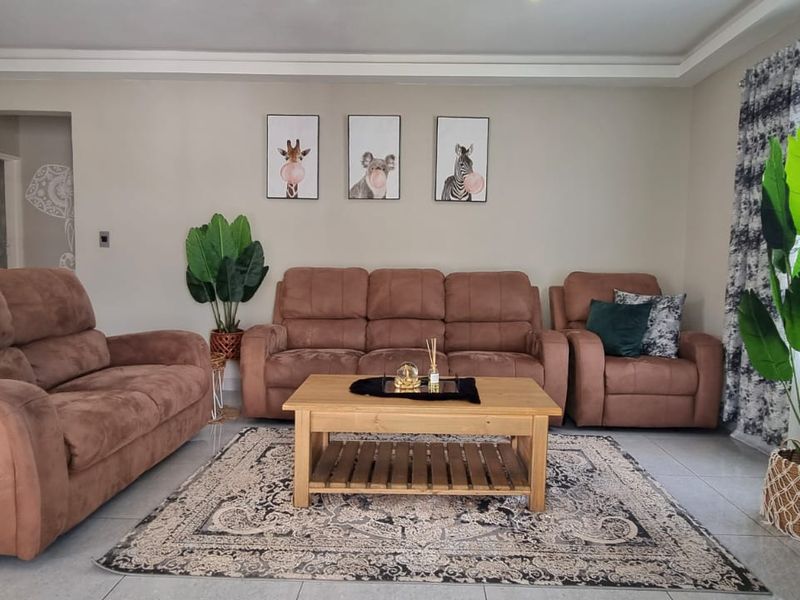 A well-maintained living room featuring neutral wall tones, tiled flooring, and a coved ceiling, providing a comfortable and inviting space.