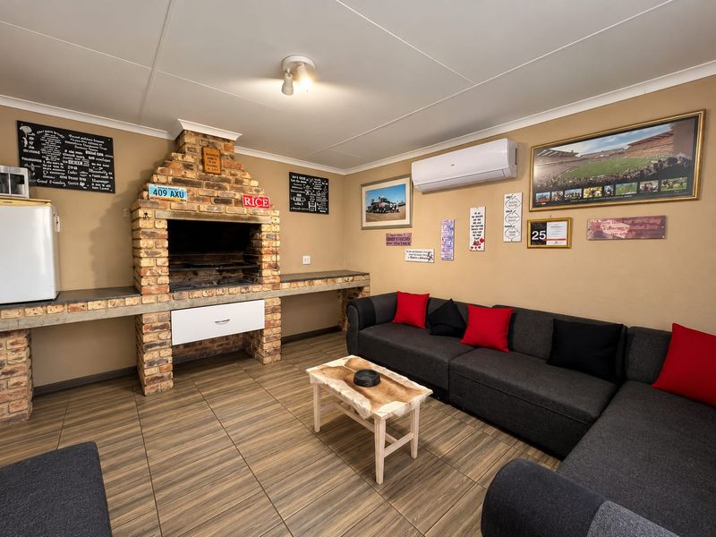 A comfortable living area featuring a prominent built-in brick fireplace with concrete counters and a wall-mounted air conditioning unit.