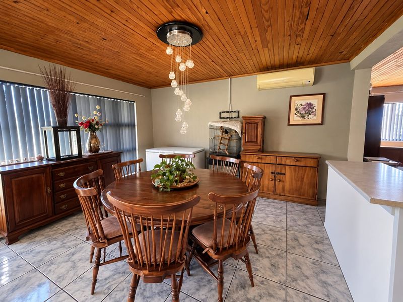 Dining area featuring a warm timber tongue and groove ceiling, ceramic tiled flooring, and a wall-mounted split system air conditioner.