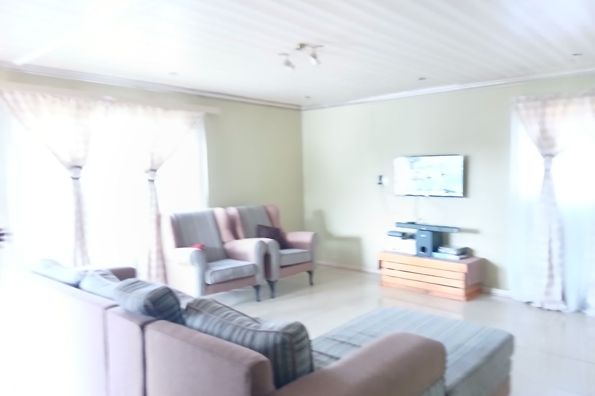 A living room area featuring tiled flooring and recessed ceiling lighting, providing a functional space for relaxation.