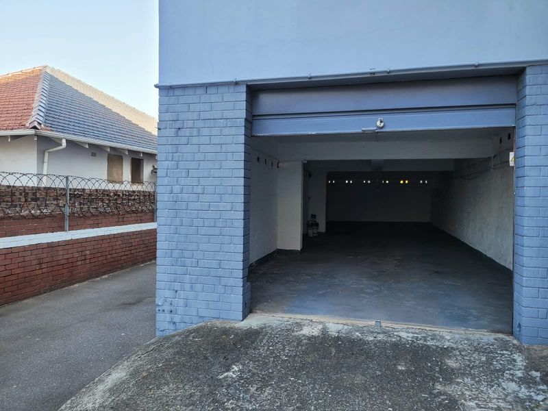 A functional, open-plan garage space with a concrete driveway and painted brick exterior finish.