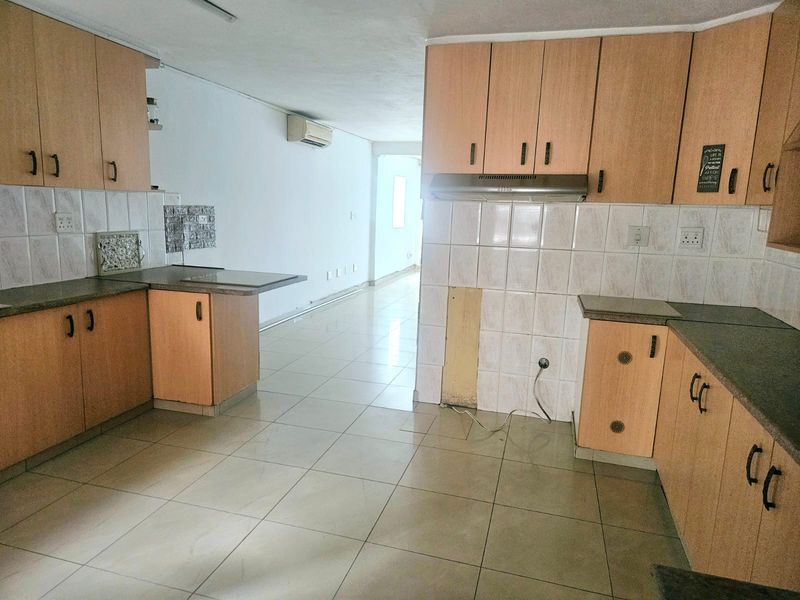A dated kitchen featuring laminate cabinetry, tiled backsplash, and tiled flooring, requiring minor repairs to cabinetry and finishes.