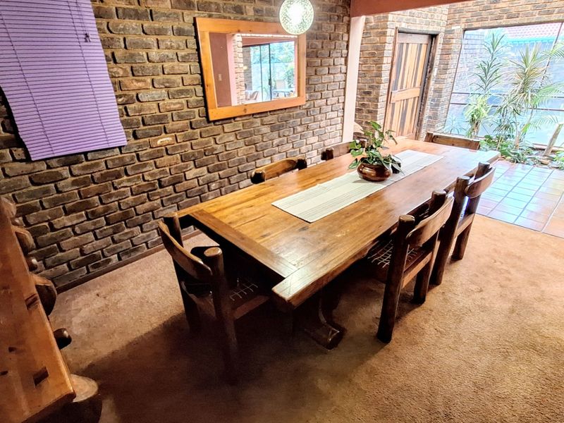 Dining room featuring exposed brick walls and direct access to an outdoor patio area.