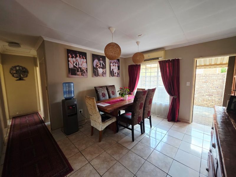 Dining room featuring tiled flooring, a split-system air conditioner, and direct access to an outdoor patio area.