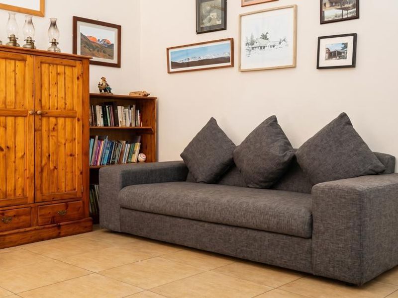 A comfortable living room area featuring neutral tiled flooring and clean wall finishes, providing a versatile space for relaxation.